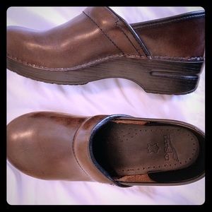 Brown Dansko clogs.